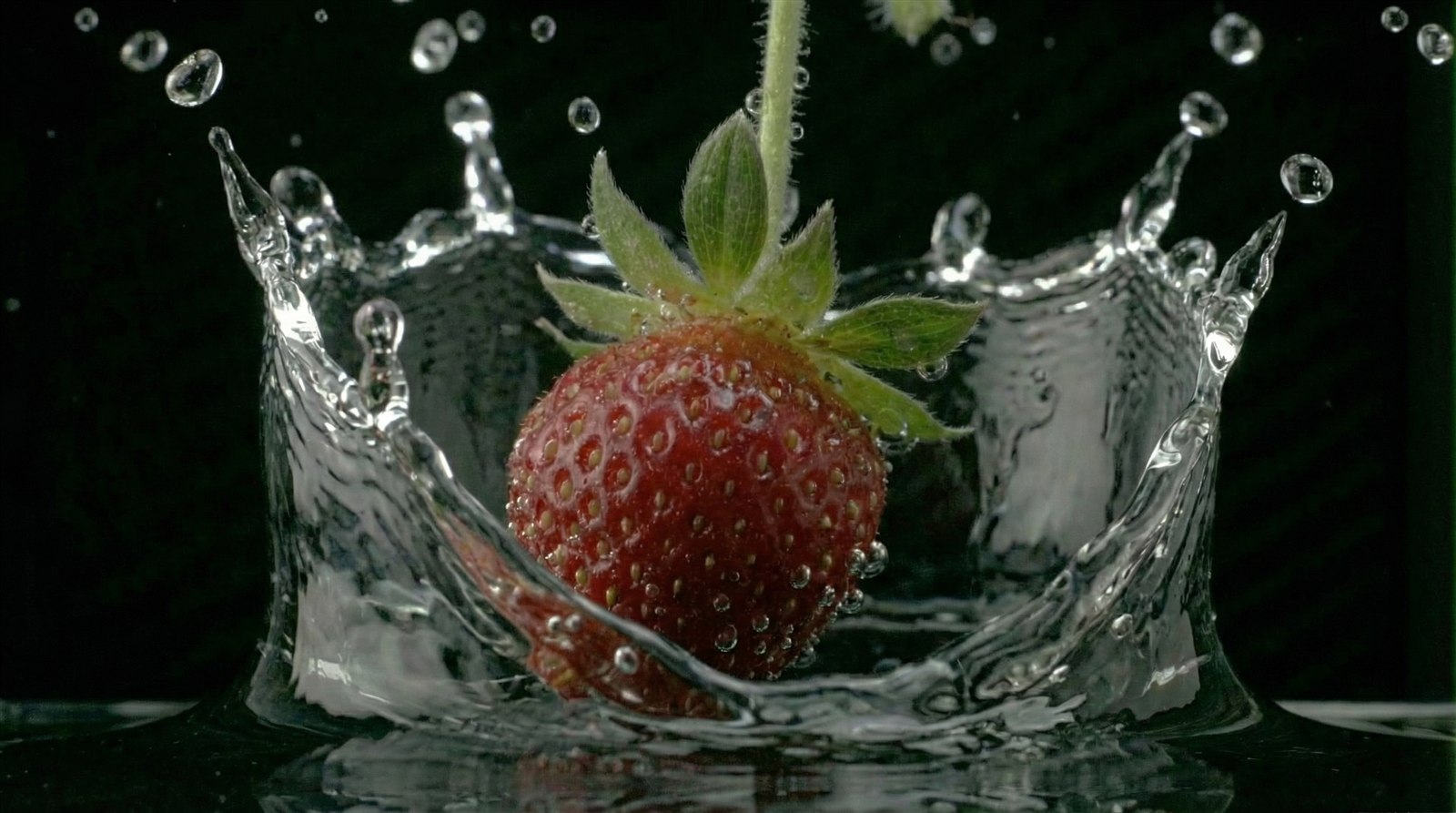 Fresa cayendo en agua como metafora de fluidos y paneles.